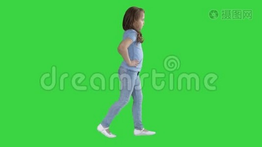 穿着便服的小女孩走在绿色屏幕上，Chroma键。视频