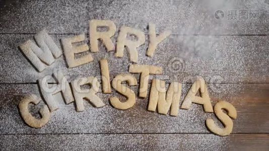 新年快乐。 圣诞快乐纸条，上面写着棕色木制背景的饼干字母。 白色粉末视频