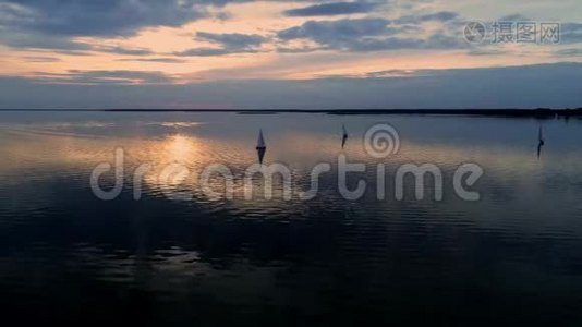 空中无人机拍摄的和平场景与游艇巡航在平静的水在黄昏。视频