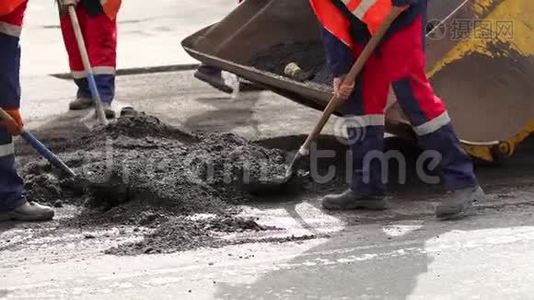工人从道路上拆除铲子旧切割沥青，用于铺设新沥青。视频