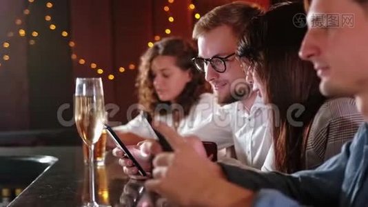 朋友、男人、女人、休闲、友谊和技术概念-在酒吧或酒吧喝啤酒的智能手机朋友视频