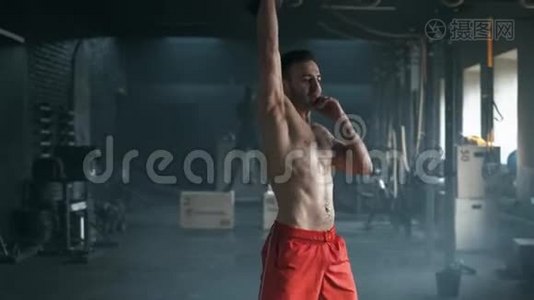 年轻的肌肉男在健身房用水壶做运动。 举重锻炼。 运动，健身理念.. 4慢视频