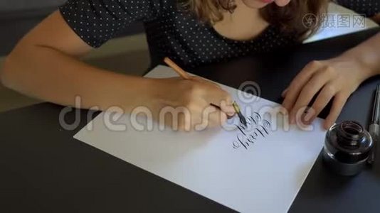 用刻字技术在一张纸上写圣诞帽书法的年轻女子特写镜头。 她写字视频