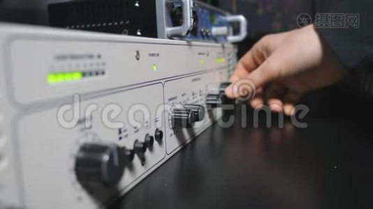 声音工程师的公手启动控制混音器面板上的音量旋钮。现代音频编辑器视频