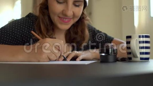 用刻字技术在一张纸上写圣诞帽书法的年轻女子特写镜头。 她写字视频