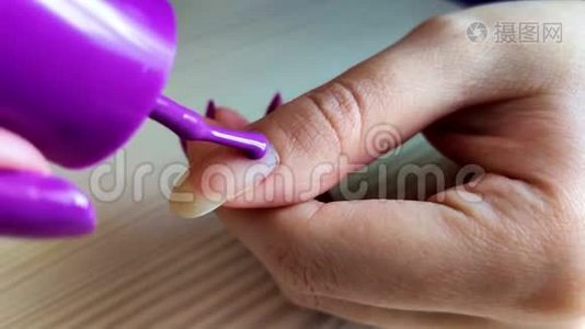 女人用紫色指甲油涂指甲视频