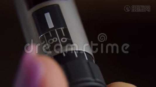 女孩在注射器笔上拿起合适剂量的胰岛素，特写。视频