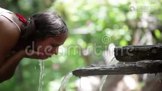 清水流入女人手`.. 年轻女子在大自然中洗了脸。 1920x1080视频