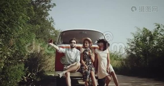 三个朋友，一起玩得很开心，穿着复古时尚的衣服，在路边的橙色老式公共汽车旁边视频