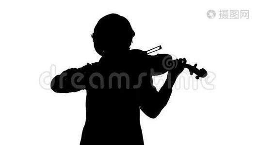 小提琴手在一间白色的工作室里演奏小提琴. 白色背景。 剪影。 慢动作视频