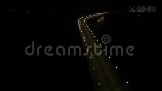 空中拍摄了一座长桥，沿途有很多灯光，交通在移动，晚上，水面反射，4K视频