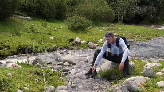 游客在森林中流动的河水中用清水洗手洗脸视频