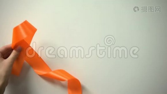 世界多发性硬化症日题字，女性在桌上放橙色丝带视频