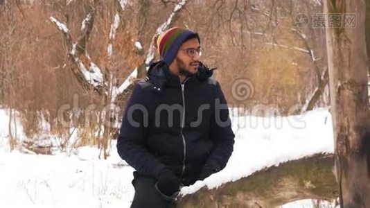 动作慢，戴眼镜的印度男人在森林里的冬天骑着木秋千视频