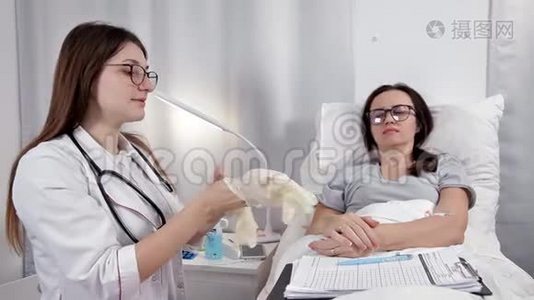 年轻的女医生戴上手套检查病人视频