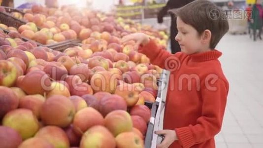 有趣的小男孩在超市的家庭购物中从盒子里摘苹果视频