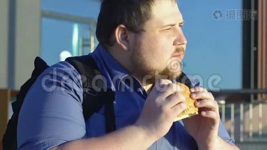 肥胖男学生在户外吃高热量汉堡、快餐和超重视频