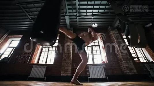 一个拳击手在健身房里踢拳击袋视频