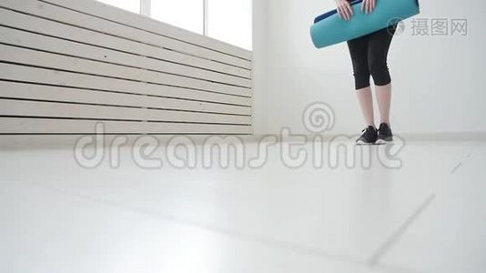 运动和健康和放松的概念。 有瑜伽垫的年轻女性，在公寓或健身房锻炼视频