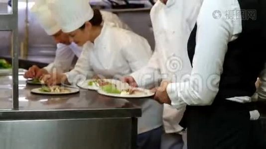 一群厨师把最后的触摸和盘子给女服务员视频