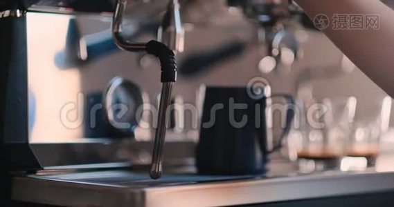 专业的女咖啡师拿着金属壶温牛奶用咖啡机。 积极微笑的女人准备视频