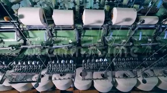 缝纫线与白色螺纹旋转在纺织厂机器上。视频