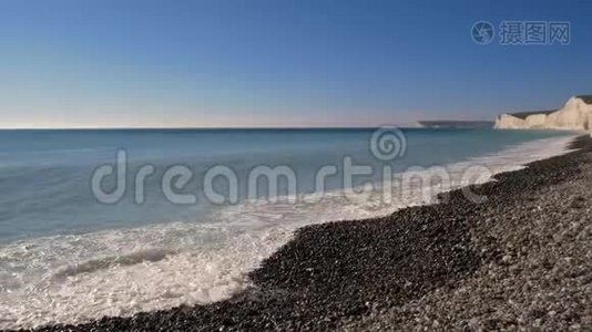 海浪撞击岩石海岸的日子，在白垩悬崖背景下视频