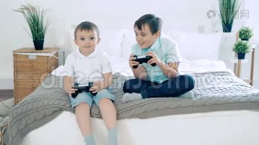两个朋友或兄弟微笑，并与控制器玩电子游戏乐趣。视频