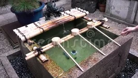 日本京都Nishiki Tenmangu神社女用手净化仪式用水视频