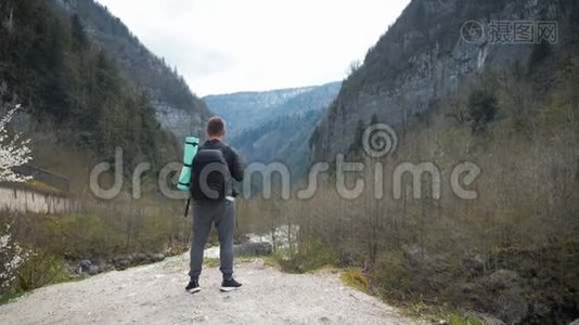 男子旅游徒步旅行者带背包，欣赏风景秀丽的山河景观。 旅行徒步旅行者远离。 旅行，人们视频