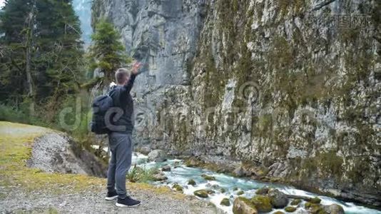 男子旅游徒步旅行者带背包，欣赏风景秀丽的山河景观。 旅行徒步旅行者远离。 旅行，人们视频