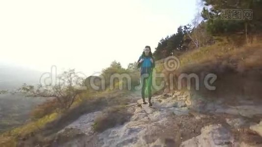 孤独的女游客背着背包在山路上旅行视频