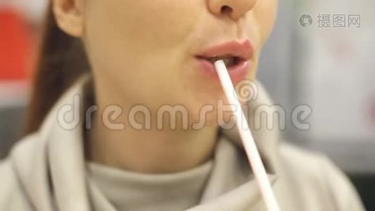 一位中年妇女在快餐店里用吸管喝奶昔。视频