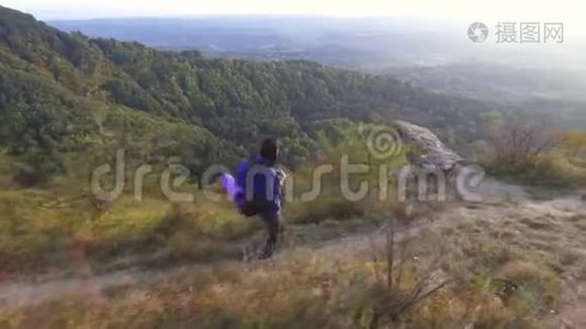 年轻的女游客背着背包独自走在山路上，四处张望视频