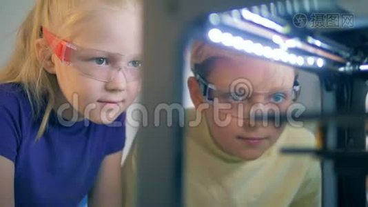 两个孩子仔细观察印刷机制视频