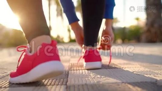 在日落时分，女人系鞋带，沿着棕榈大道奔跑。 背面视频