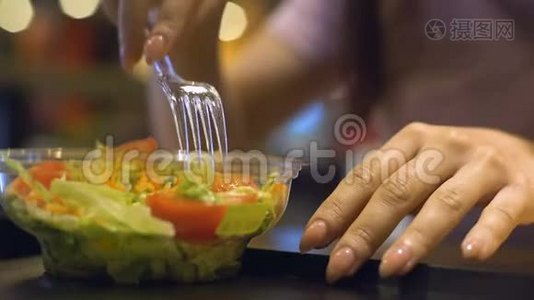 女性从塑料盘子里拿蔬菜沙拉，晚餐休息，减肥视频