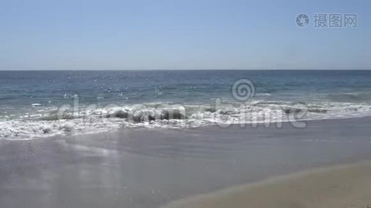 太平洋的波浪在加州马里布海滩的岸边拍打。 沙滩上温暖阳光的夏日视频