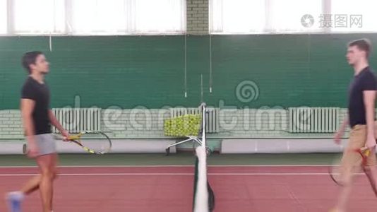 网球场上的两个年轻的健康男子走近网球场，握手视频