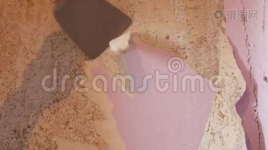 男建筑工人`修理时从墙上撕下旧的粉红色墙纸视频
