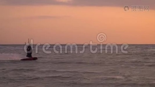 海上运动，人们在日落背景下从事风筝冲浪。 缓慢移动视频