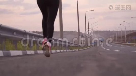 积极的生活方式和保健。 一个穿着白色T恤和轻便运动鞋的运动女孩走在后面的一条空跑道上视频