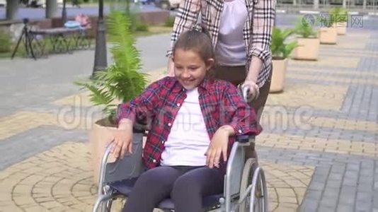 女孩骑着轮椅在夏季公园快乐少年。 慢节奏视频