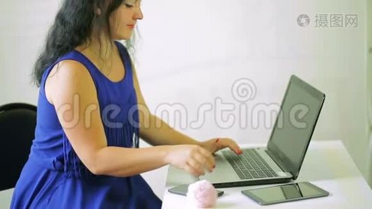 年轻女子在笔记本电脑上工作，接电话。 摄像机从下往上移动视频