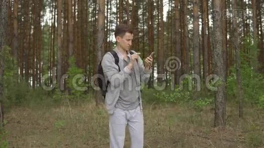 森林里试图捕捉移动信号的年轻人视频