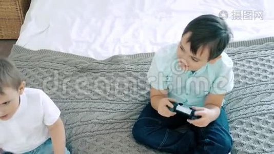 两个朋友或兄弟微笑着玩一个有控制器的电子游戏视频