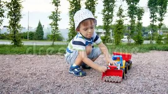 3岁幼儿用玩具挖掘机在操场玩耍的4k录像视频