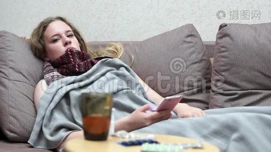 少女饮药茶暖.. 躺在沙发上用智能手机视频