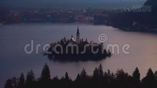 以阿尔卑斯山山脉为背景的斯洛文尼亚小岛布莱德湖和教堂的空中日落景色视频