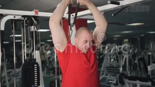 肌肉男在健身房锻炼时，做缆绳，肱三头肌，向下推运动。视频